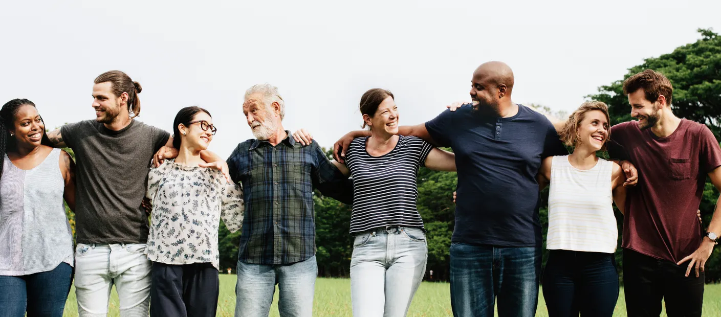 A group of adults standing arm in arm outdoors